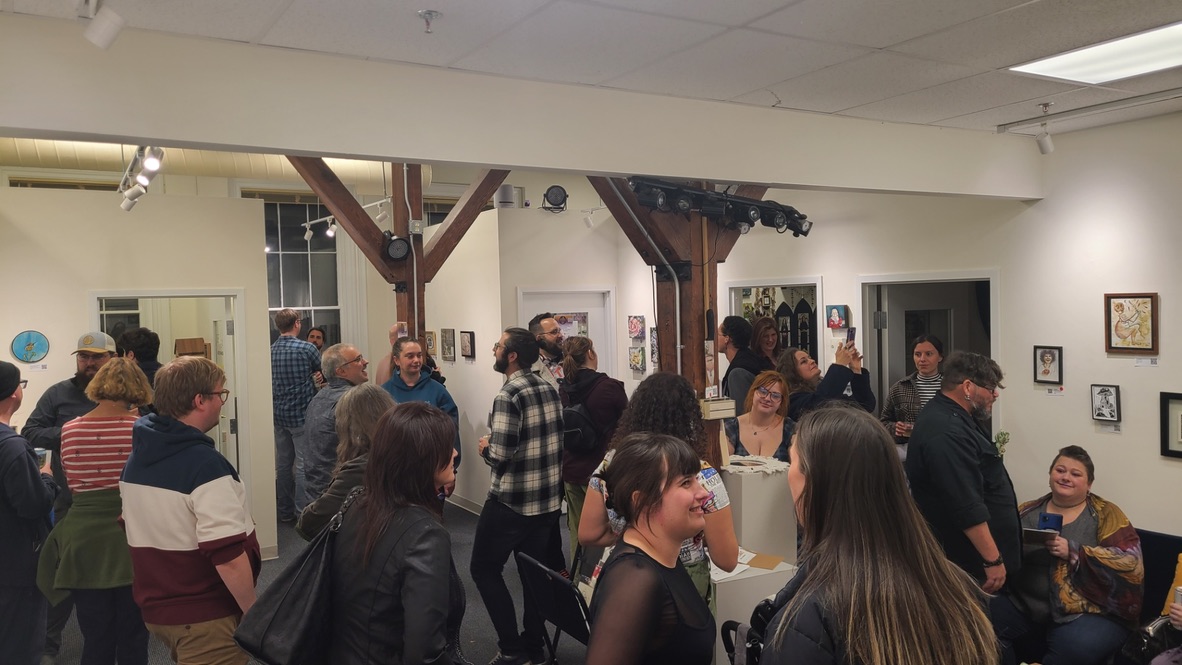 A wide shot of an opening reception inside Mosaic Art Collective